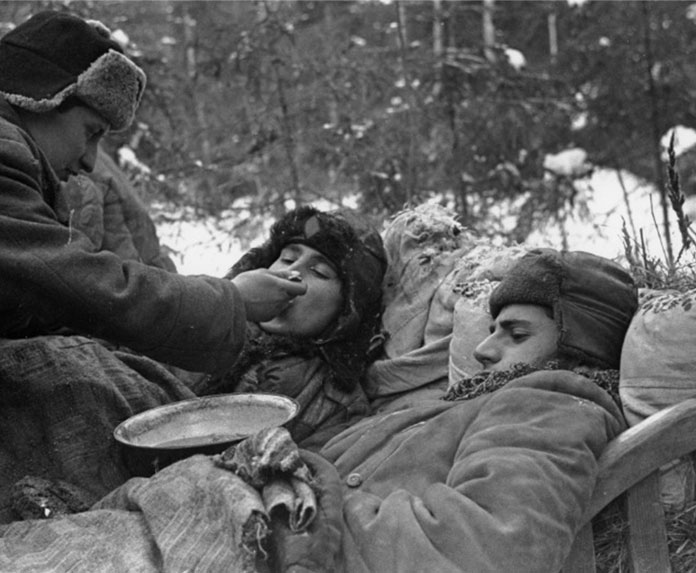 A partisan feeding a wounded comrade in a Soviet partisan camp, photographed by Yakov Davidson. Source: Ghetto Fighter's House